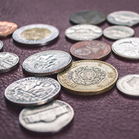 Scattered coins on a flat surface. Photo by Steve Johnson on Unsplash