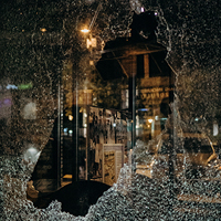 Broken store window at night time. Photo by Amber Kipp on Unsplash