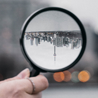 Person holding magnifying glass during daytime. Photo by Sam on Unsplash