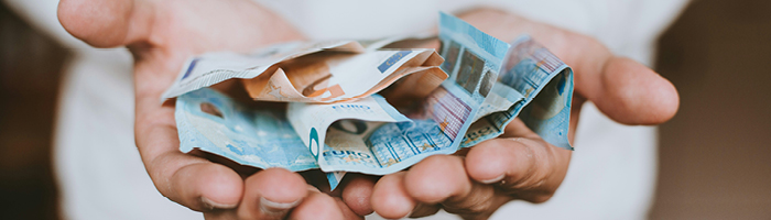 Pair of hands holding euro notes. Photo by Christian Dubovan on Unsplash