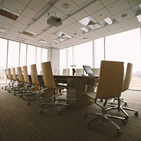 Oval brown wooden conference table and chairs inside conference room. Photo by Benjamin Child on Unsplash