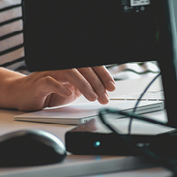 Person using computer on a table. Photo by Sigmund on Unsplash