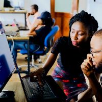 Woman and man sitting in front of monitor. Photo by Desola Lanre-Ologun on Unsplash