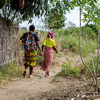 A Vulnerable Lives Survey (VLS) enumerator walking through the neighborhoods of Monapo with a local guide, Nampula Province (Photo: IGM)